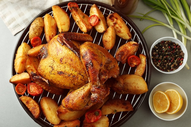 Grilled beer can chicken with vegetables on table