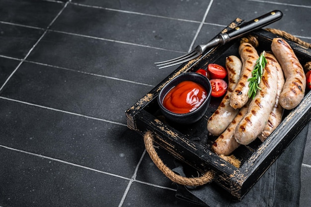 Grilled Bratwurst meat sausages with herbs and spices Black background Top view Copy space