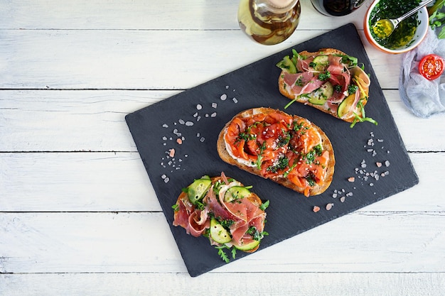 Grilled bruschetta with salmon fillet and jamon Delicious Italian bruschetta antipasti Top view