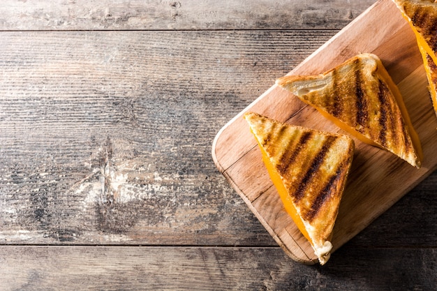 Grilled cheese sandwich on wooden table top view copy space