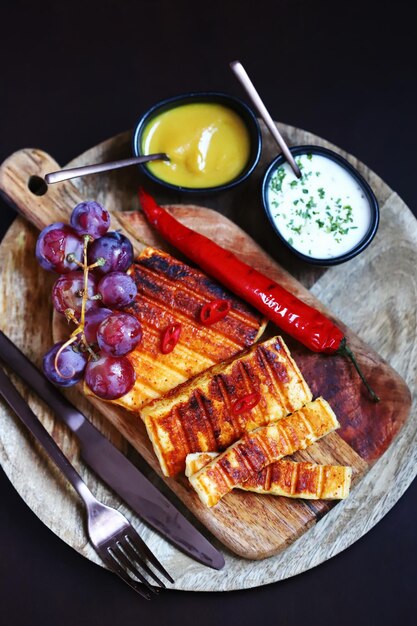 Grilled cheese with chili pepper on a wooden board