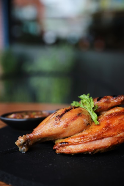 Grilled chicken on black dish wood background