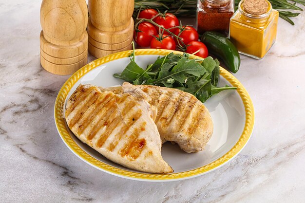 Grilled chicken breast served arugula and tomatoes