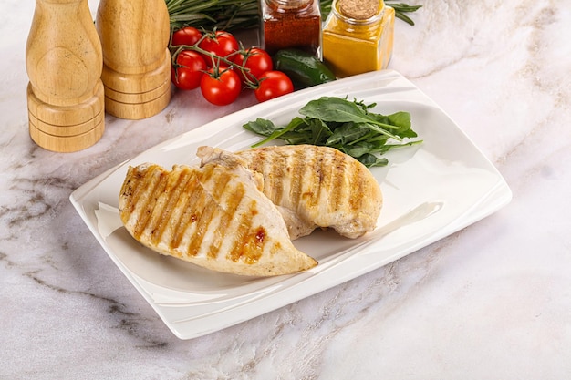 Grilled chicken breast served arugula and tomatoes