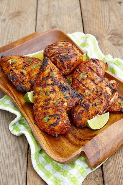 Grilled chicken breast served with herbs and lime