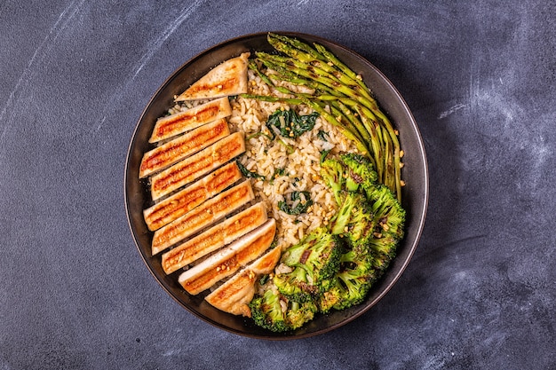 Petto di pollo alla griglia con riso integrale, spinaci, broccoli, asparagi, concetto di dieta, mangiare sano.