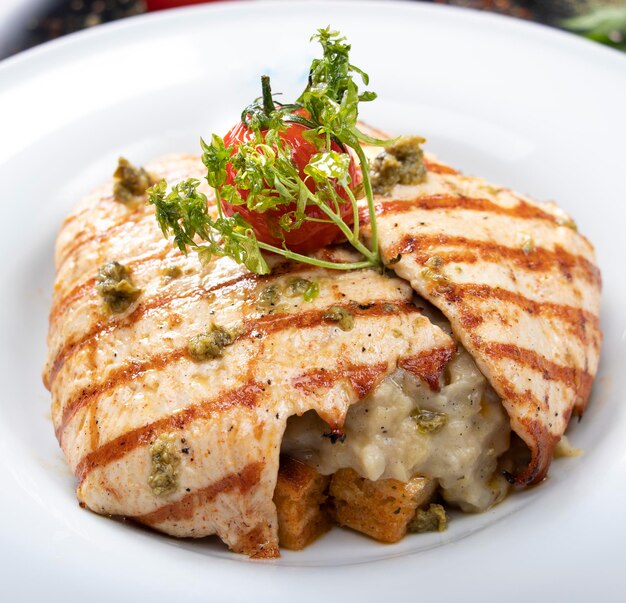 Foto petto di pollo alla griglia con insalata verde e patatine fritte su un piatto bianco