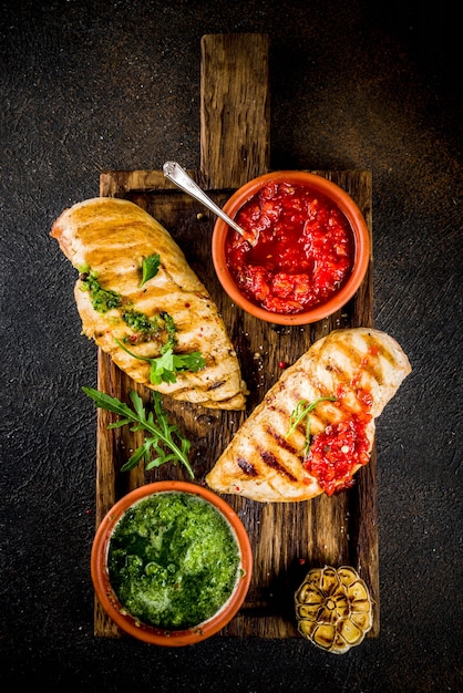 Grilled chicken breast with spicy sauces, tomatoes and herbs