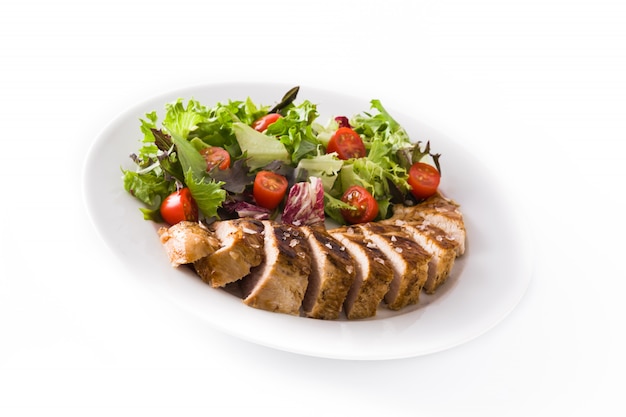 Grilled chicken breast with vegetables on a plate isolated 
