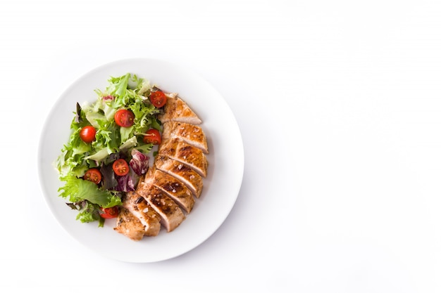 Photo grilled chicken breast with vegetables on a plate isolated