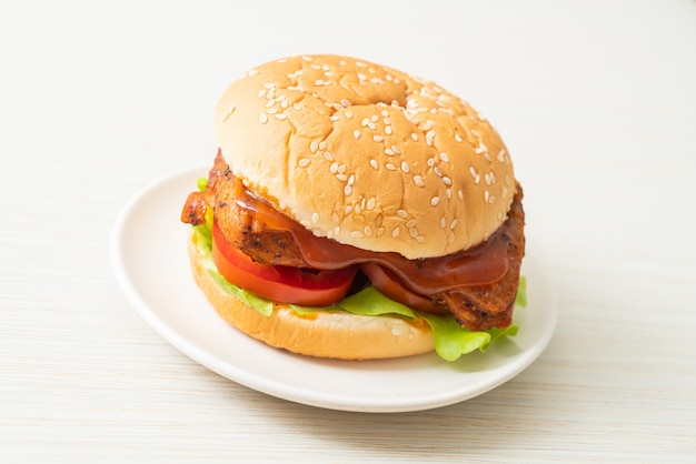 Hamburger di pollo alla griglia con salsa su piatto bianco