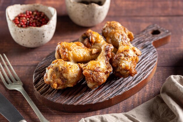 Photo grilled chicken drumette on cutting board