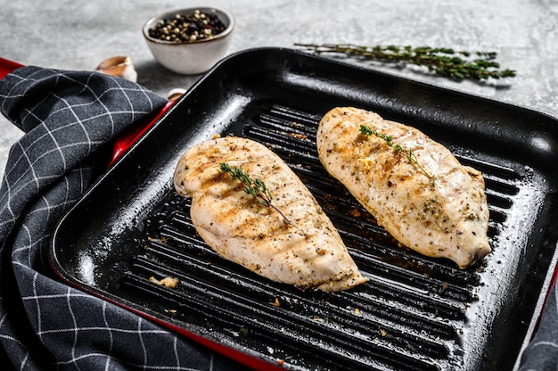 Grilled chicken fillet breasts on a cooking pan. gray background. Top view