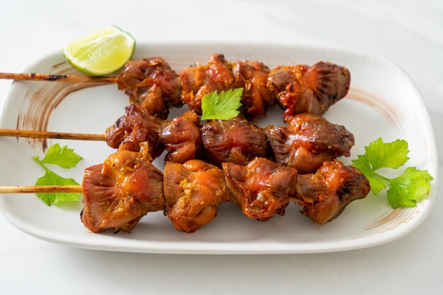 grilled chicken gizzard skewer with herbs and spices on plate