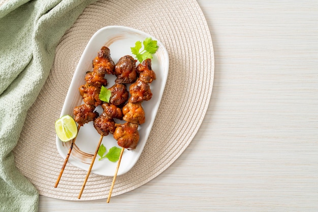 grilled chicken gizzard skewer with herbs and spices on plate