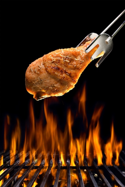 Grilled chicken leg on the flaming grill