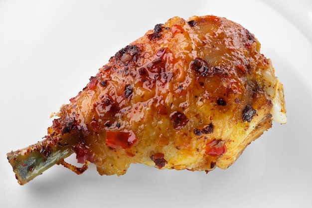 Grilled chicken leg with spicy aromatic sweet sauce with pepper close-up