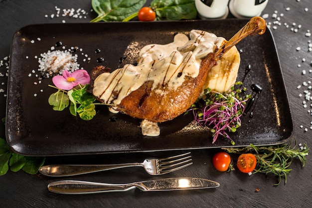 Grilled chicken leg with tasty sauce on wooden background