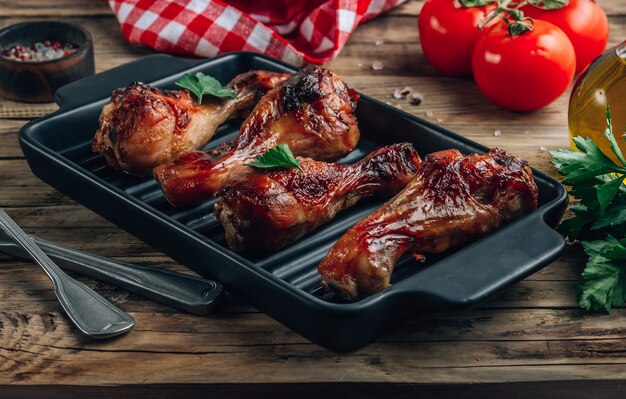 Grilled chicken legs with spices on black plate