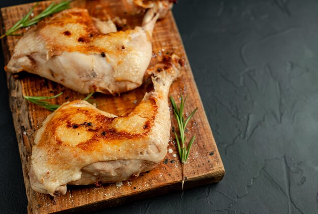 grilled chicken legs with spices and herbs, ready for cooking on a stone background.