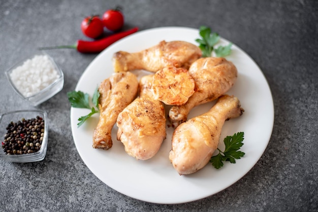 grilled chicken legs with spices on a stone background