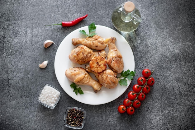 grilled chicken legs with spices on a stone background