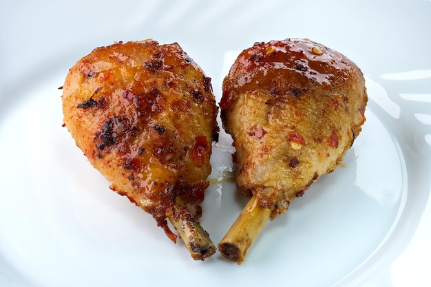 Grilled chicken legs with spicy aromatic sweet sauce with pepper close-up