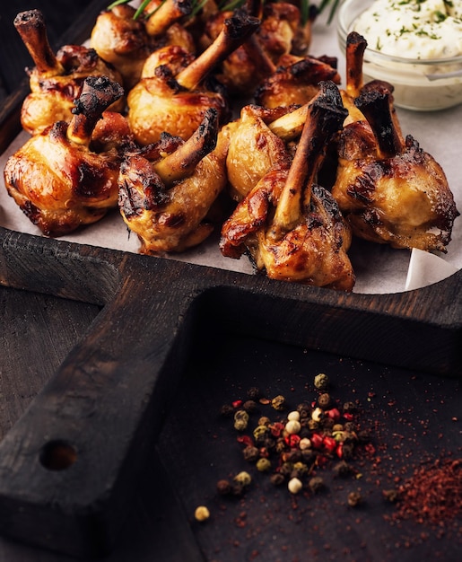 Grilled chicken legs on wooden tray