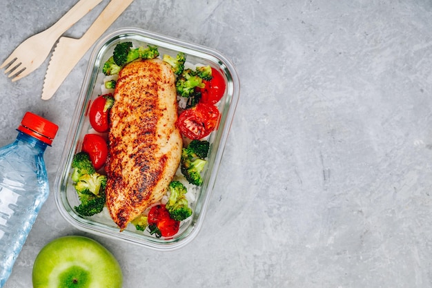 Grilled chicken meal prep containers with rice broccoli and tomatoes Healthy lunch with vegetables copy space