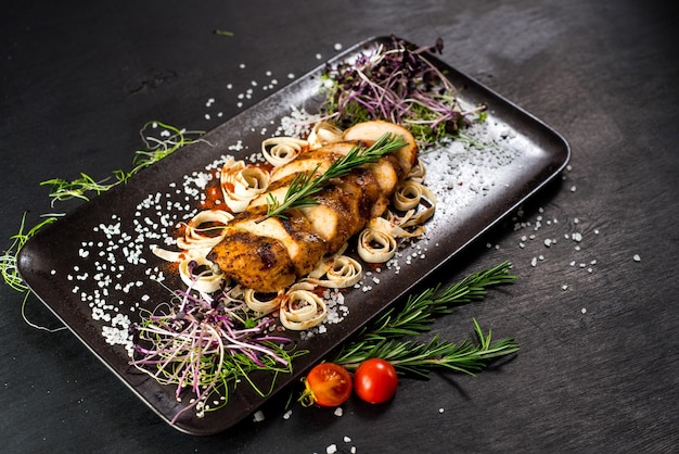 Grilled chicken meat medallions on black background