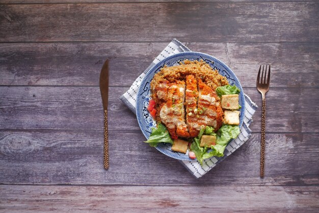 グリルチキンライスと新鮮な野菜のサラダをテーブルに