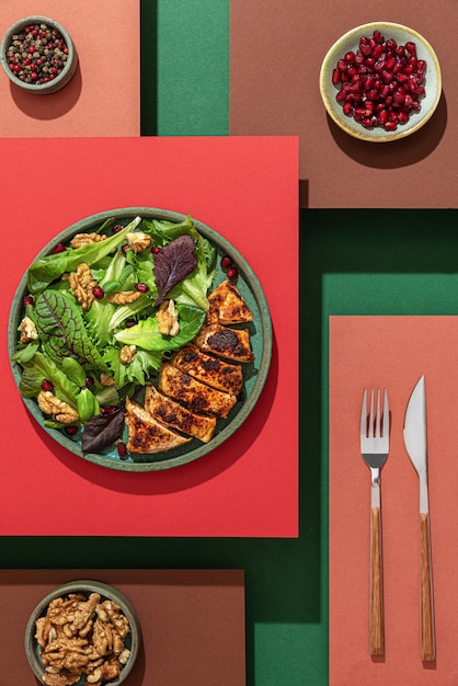Grilled chicken salad on abstract colorful layered background Creative food concept Colorful minimalism Top view Flat lay