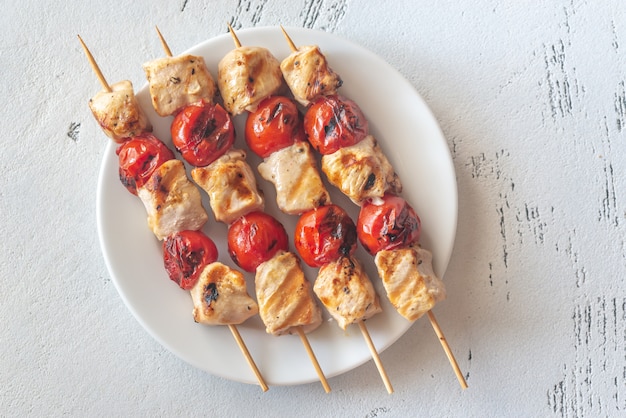 Grilled chicken skewers on the white plate