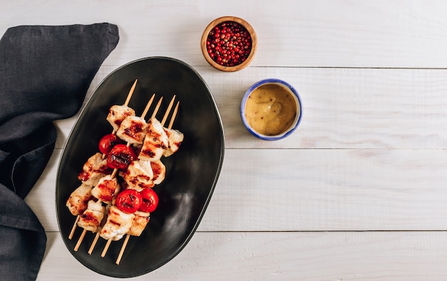 Grilled chicken skewers with cherry tomatoes on a plate