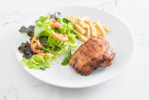 Bistecca di pollo alla griglia con patatine fritte e insalata di verdure