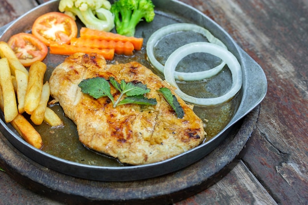 Photo grilled chicken steaks and french fries with vegetable