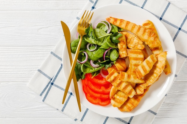 野菜とプレート上のグリルチキンストリップ