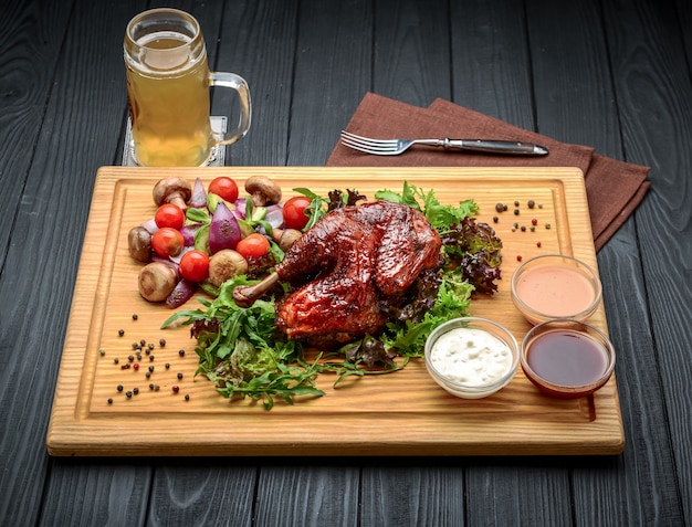 Grilled chicken Tabaka with sauce on stone plate.