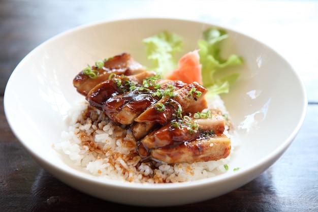 木材の背景にグリルした鶏の照り焼きご飯