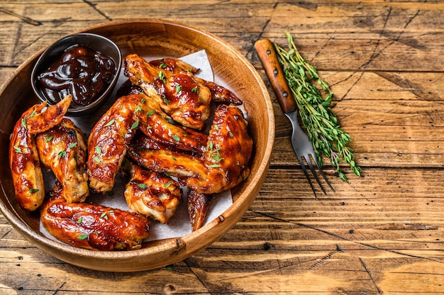 Grilled chicken wings  with bbq sauce. wooden background. Top view. Copy space.