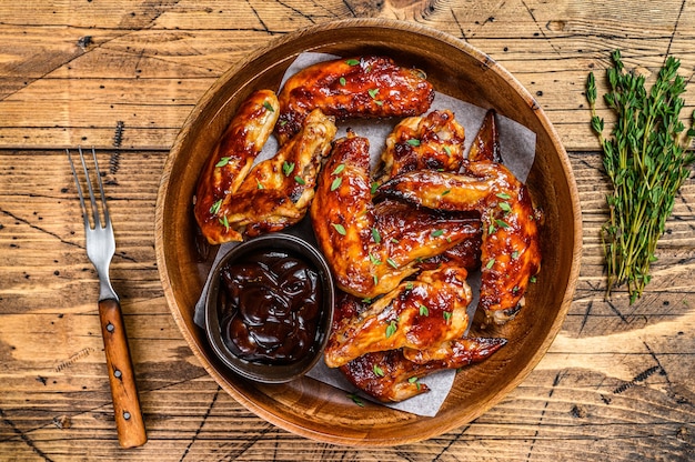 Grilled chicken wings  with bbq sauce. wooden background. Top view.