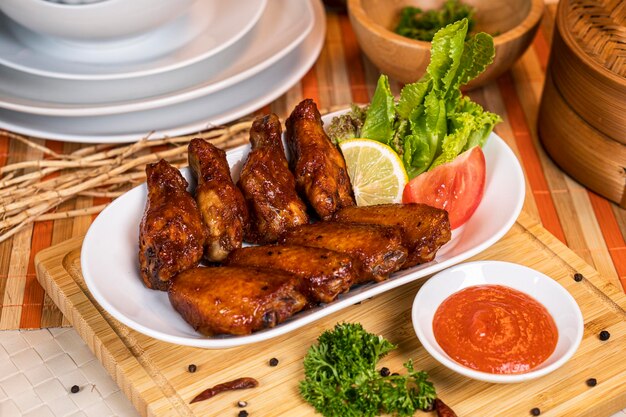 Grilled chicken wings with ketchup and sauces on a xAunique plate Traditional baked bbq