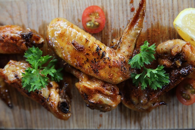 Grilled Chicken Wings with Red Spicy Sauce on wood background