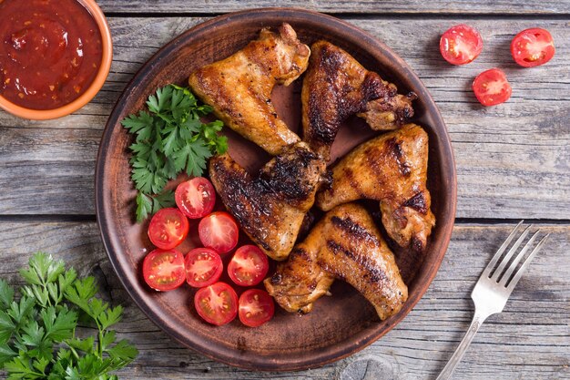 Grilled chicken wings with sauce tomato and parsley