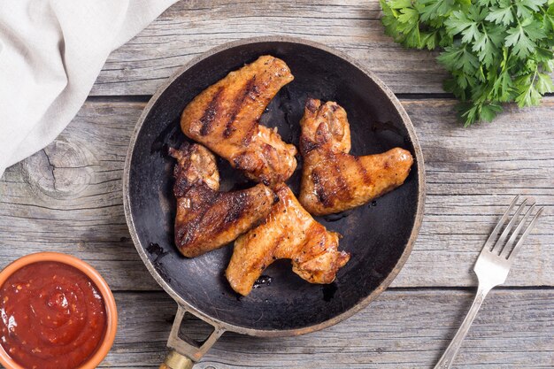 Grilled chicken wings with sauce tomato and parsley