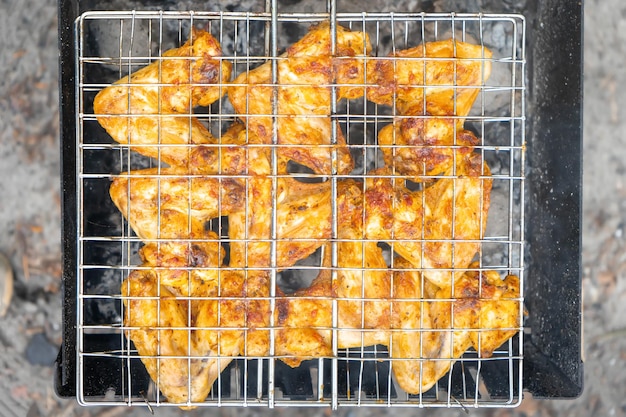 Grilled chicken wings with spices on the grill cooked on fire barbecue