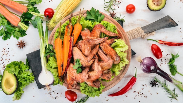 Grilled Chicken Wings with Vegetables and Carrots On a wooden background Top view Copy space