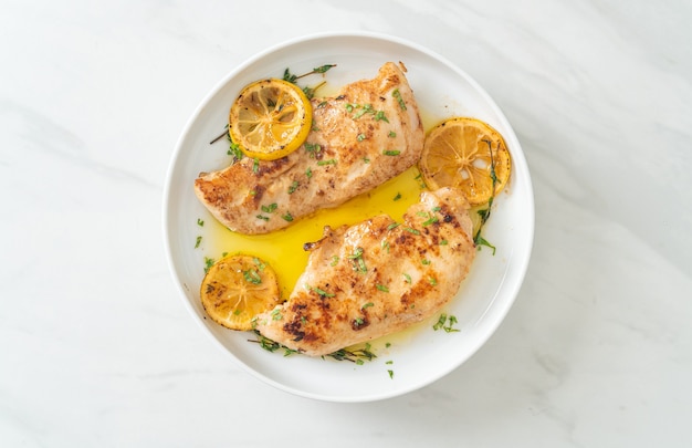 grilled chicken with butter, lemon and garlic on white plate