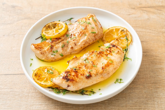 grilled chicken with butter, lemon and garlic on white plate