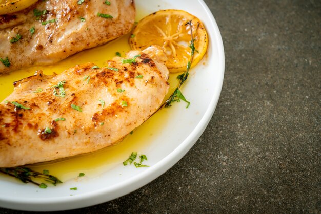 курица-гриль с маслом, лимоном и чесноком на белой тарелке